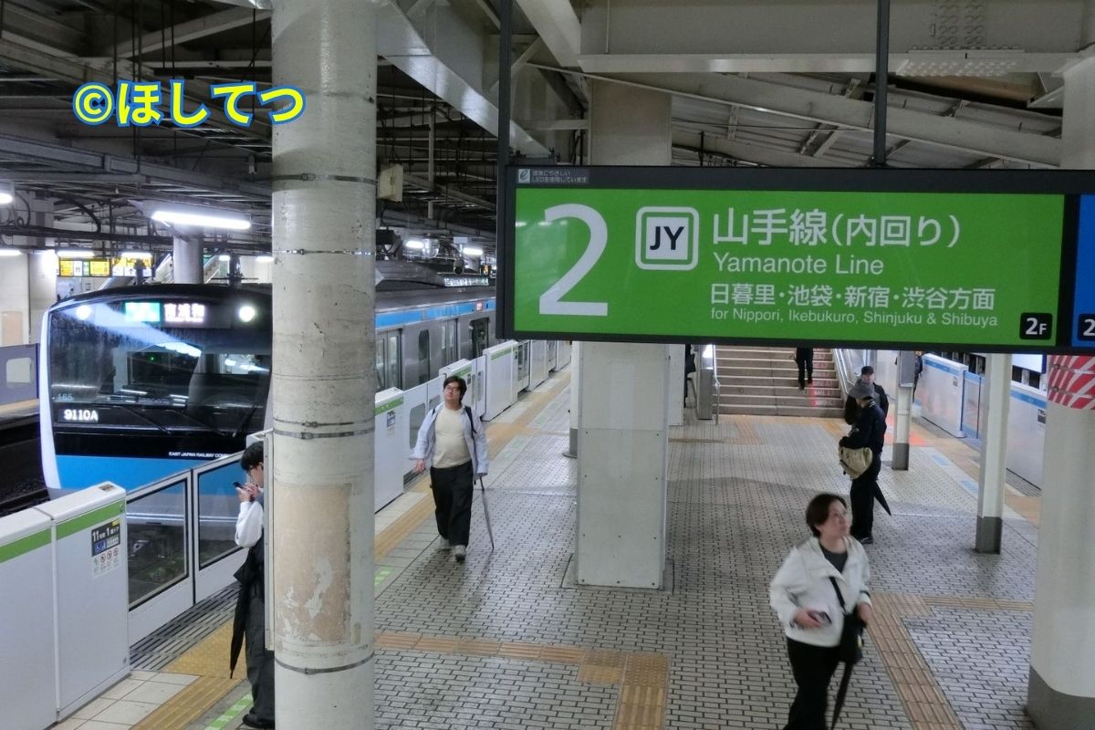 Yamanote Line signboard and E233 series Keihin-Tohoku Line seen from stairs at Ueno Station