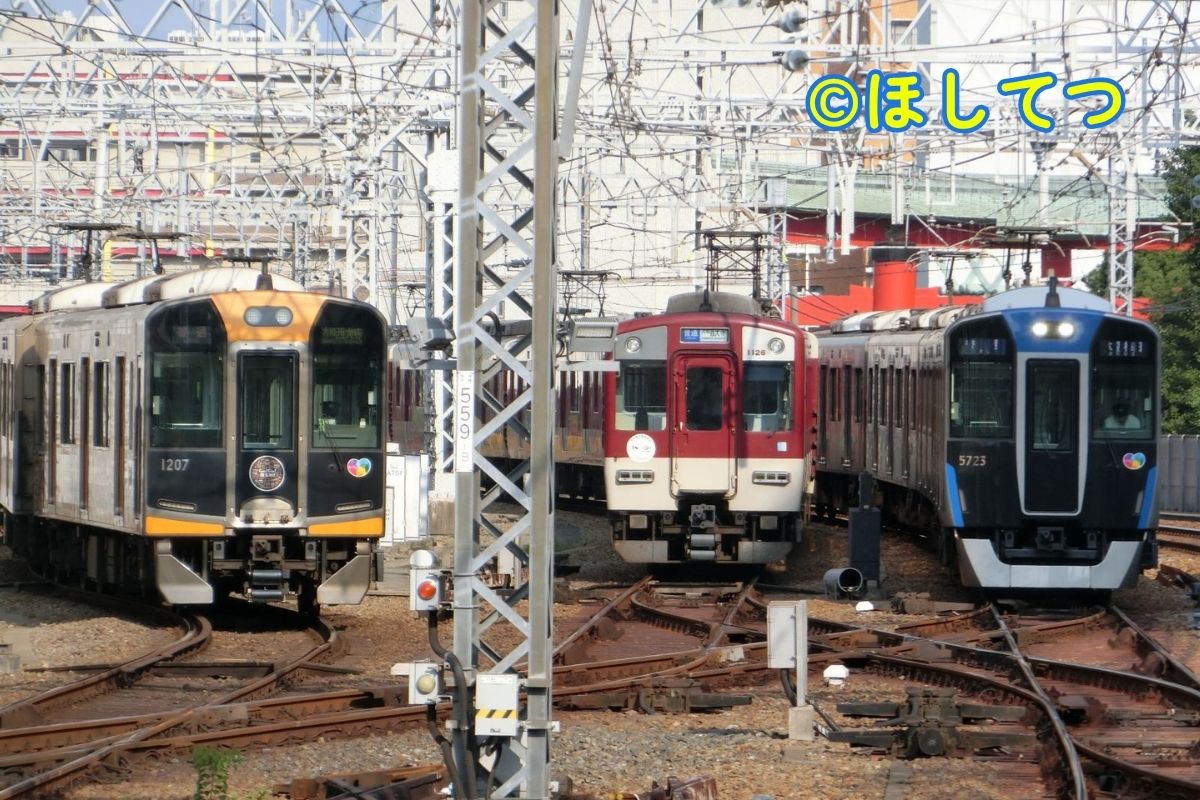 Hanshin 1000 Series, Kintetsu 1026 Series, and Hanshin 5700 Series triple side by side at Amagasaki Station