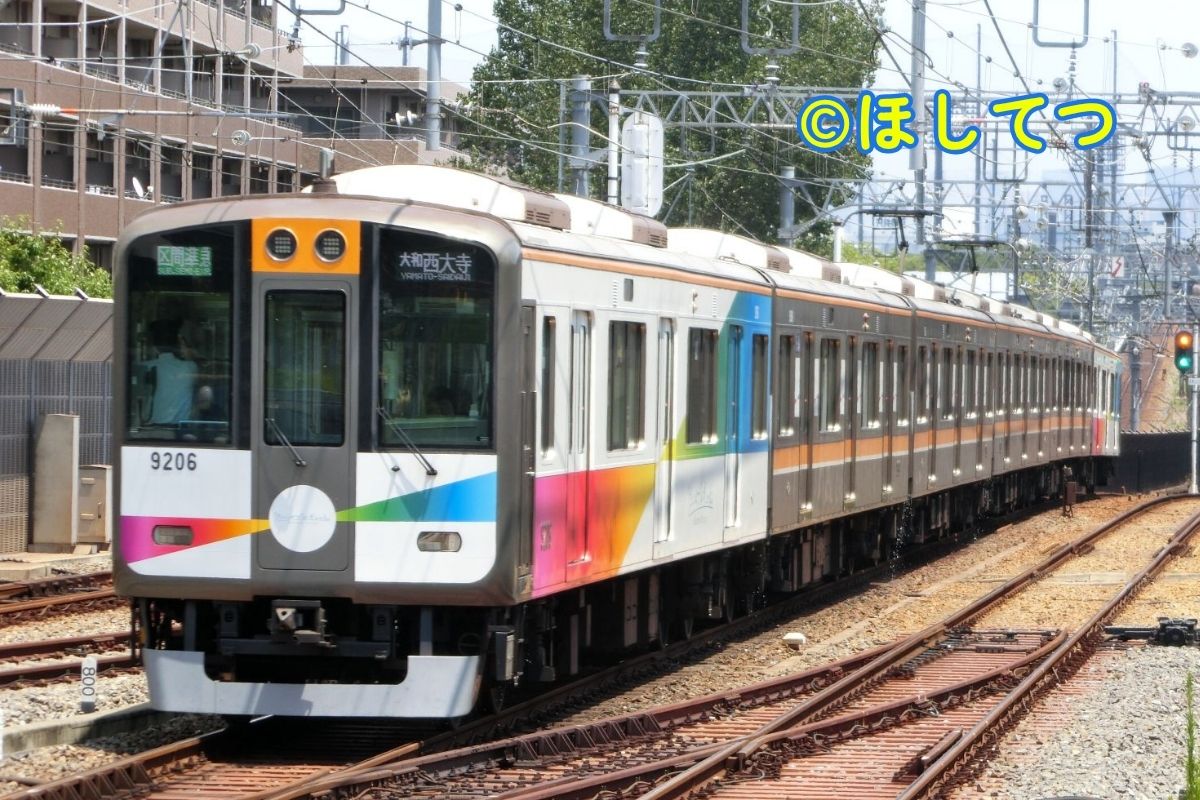 Hanshin 9000 Series Taisetsu Ga Gyutto rainbow wrapping train at Amagasaki Station